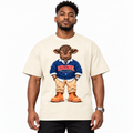 A man wearing a cream-colored t-shirt with a graphic of a cartoon sheep dressed in a blue sweater that says 'URBANDEL'. The background is solid white.