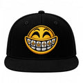 A black flat-brim baseball cap featuring a large embroidered yellow smiley face with gold grillz on a white background.